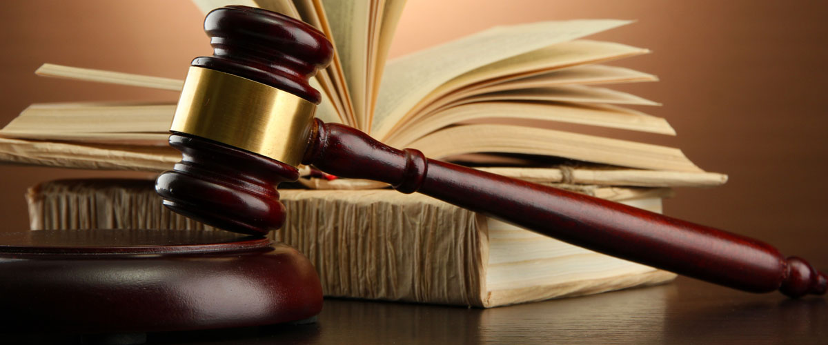 wooden gavel and books on wooden table,on brown background
